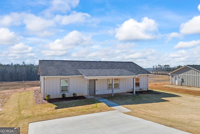 single story home with covered porch and a front yard