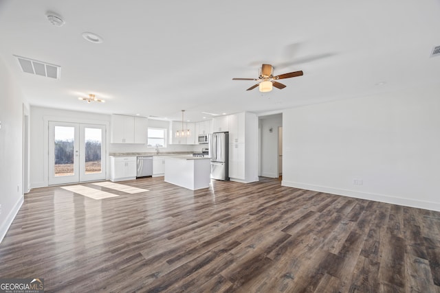 unfurnished living room featuring ceiling fan, french doors, sink, and wood-type flooring