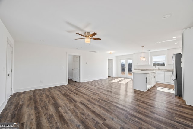 unfurnished living room featuring french doors, ceiling fan, and dark wood-type flooring