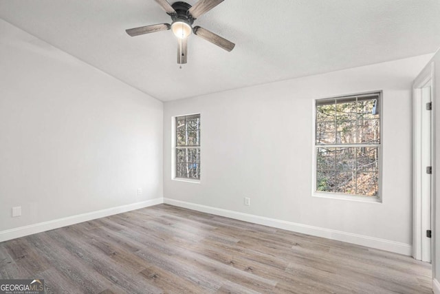 unfurnished room featuring ceiling fan, light wood-type flooring, and vaulted ceiling