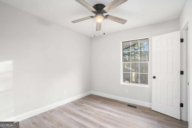 spare room with light wood-type flooring and ceiling fan