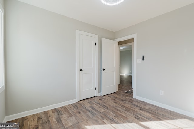 unfurnished bedroom featuring baseboards and wood finished floors