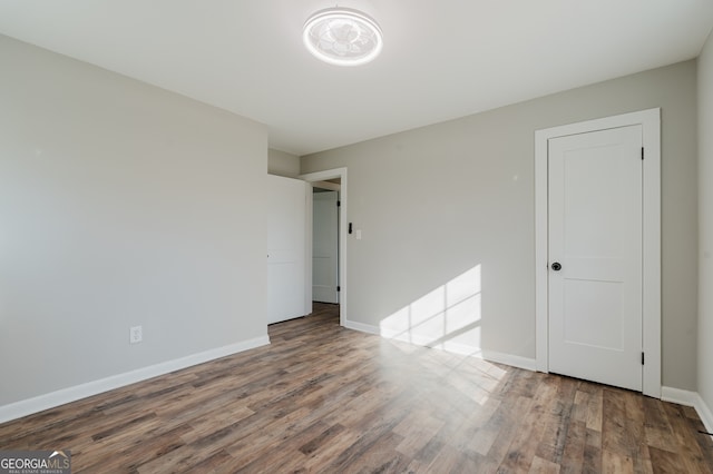 spare room with wood finished floors and baseboards