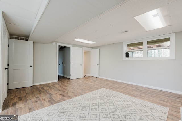 basement featuring baseboards and wood finished floors