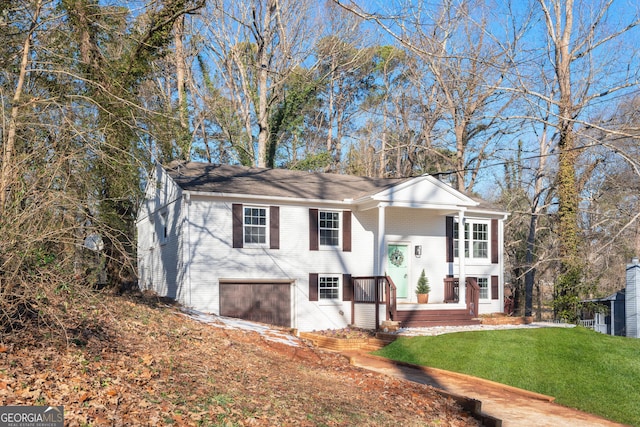 split foyer home featuring an attached garage, a front lawn, and brick siding