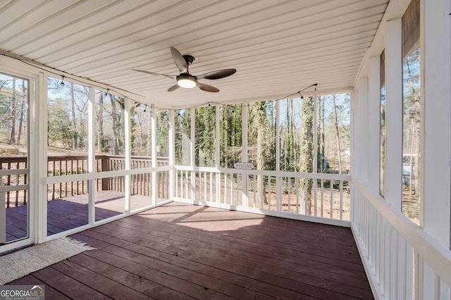 unfurnished sunroom featuring a ceiling fan