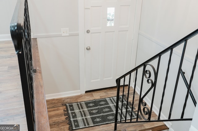 entryway with stairs, wood finished floors, and baseboards