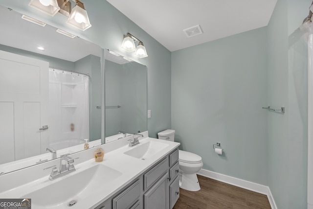 bathroom featuring toilet, walk in shower, vanity, and hardwood / wood-style floors