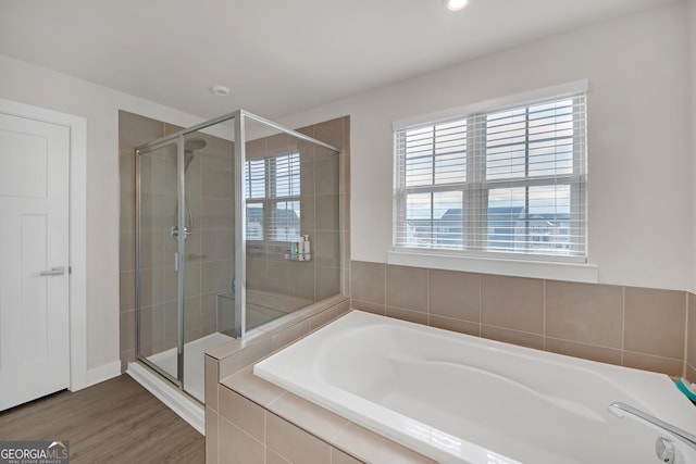 bathroom featuring hardwood / wood-style flooring, plenty of natural light, and plus walk in shower