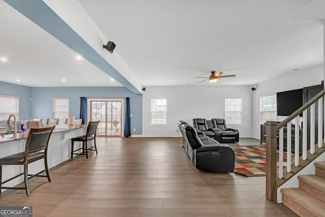 living room with sink, ceiling fan, and light hardwood / wood-style flooring