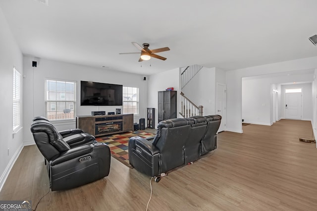 living room with ceiling fan and light hardwood / wood-style flooring