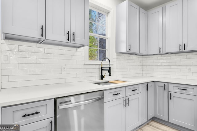 kitchen featuring dishwasher, backsplash, and sink