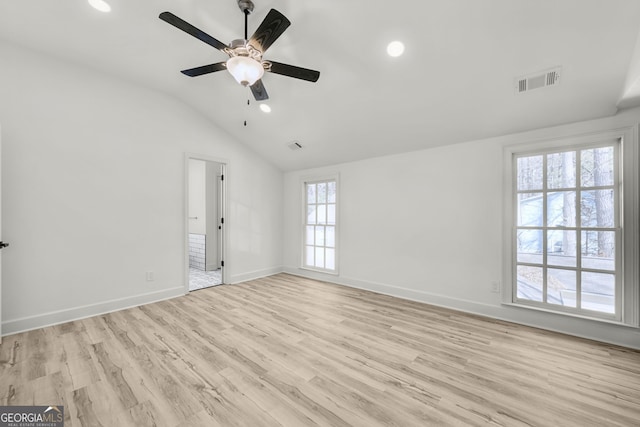 spare room with ceiling fan, a wealth of natural light, lofted ceiling, and light hardwood / wood-style floors