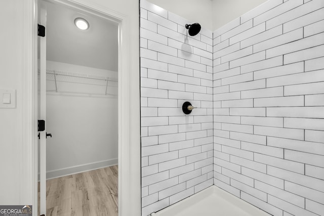 bathroom featuring hardwood / wood-style flooring and tiled shower