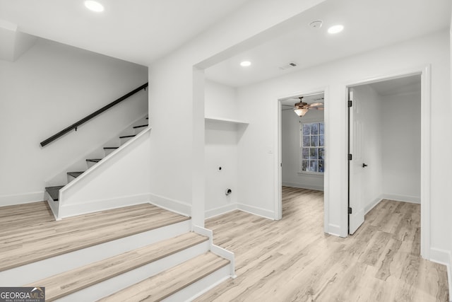 stairway with hardwood / wood-style flooring and ceiling fan