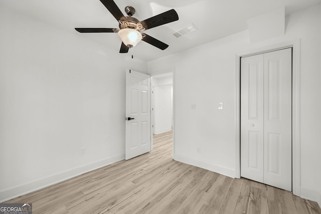 unfurnished bedroom with ceiling fan, light hardwood / wood-style floors, and a closet