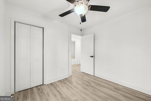 unfurnished bedroom featuring ceiling fan, light hardwood / wood-style flooring, and a closet