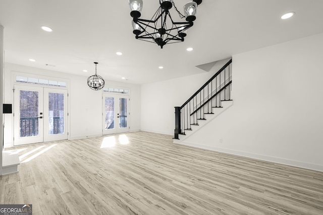 unfurnished living room featuring french doors and light hardwood / wood-style floors