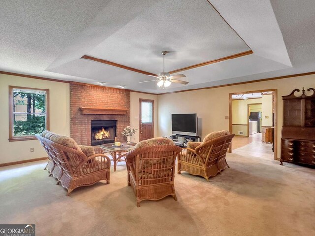 living room with ceiling fan, light carpet, a fireplace, and a tray ceiling