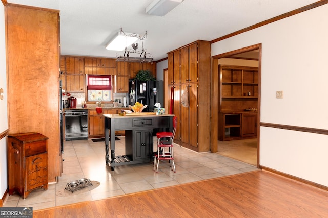 114 Tracy Ln, Mcdonough, GA 30253 - kitchen with black appliances, brown cabinets, ornamental molding, light tile patterned floors, and light countertops