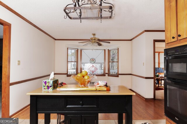 kitchen featuring a kitchen breakfast bar, black appliances, a center island, light tile patterned floors, and a textured ceiling