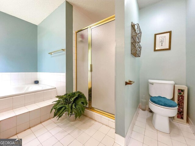 bathroom featuring toilet, tile patterned flooring, a textured ceiling, and separate shower and tub