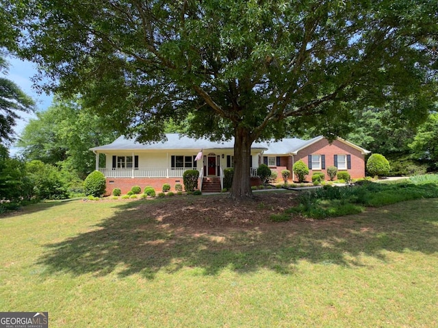 ranch-style house featuring covered porch and a front lawn