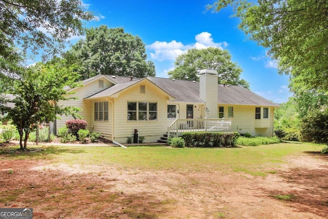 back of house featuring a deck and a lawn