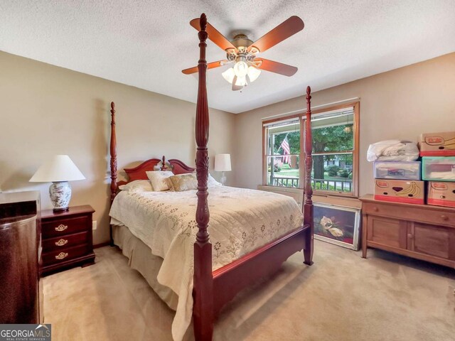 carpeted bedroom with a textured ceiling and ceiling fan