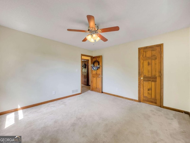 spare room with ceiling fan and light carpet