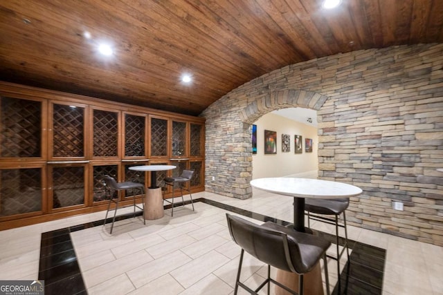 wine room with lofted ceiling, wooden ceiling, and light tile patterned floors