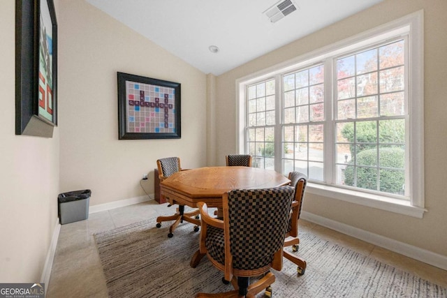 dining space with lofted ceiling and light tile patterned flooring