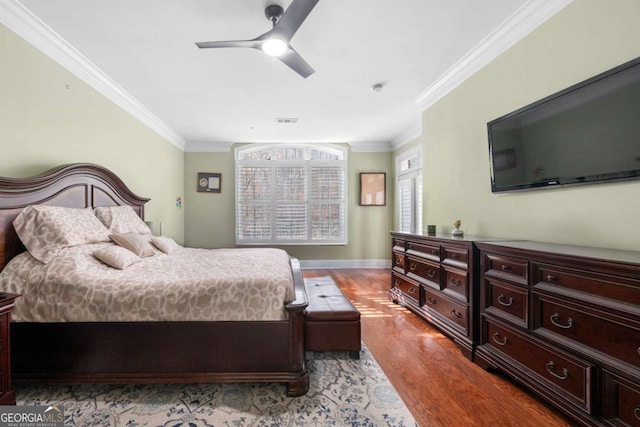 bedroom featuring ceiling fan, crown molding, and light hardwood / wood-style flooring