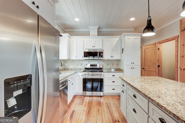 kitchen with stainless steel appliances, pendant lighting, light stone counters, decorative backsplash, and white cabinets