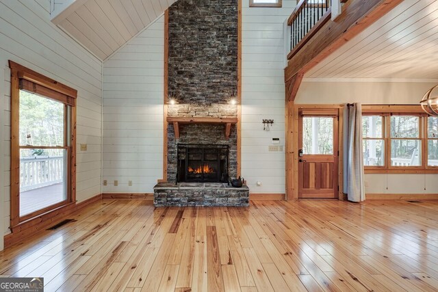 unfurnished living room featuring high vaulted ceiling, light hardwood / wood-style flooring, and a wealth of natural light