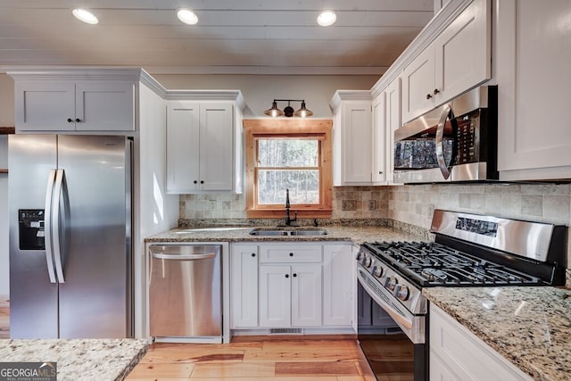 kitchen featuring appliances with stainless steel finishes, white cabinets, and sink