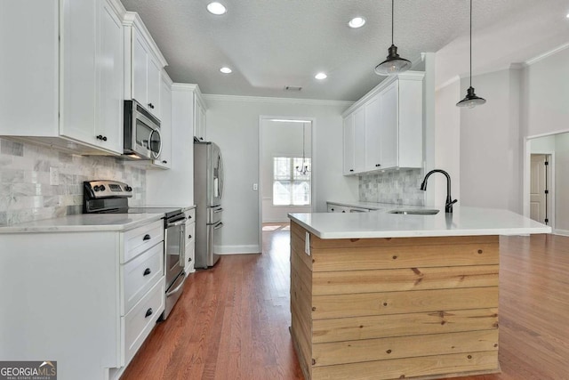 kitchen featuring pendant lighting, decorative backsplash, white cabinets, appliances with stainless steel finishes, and sink