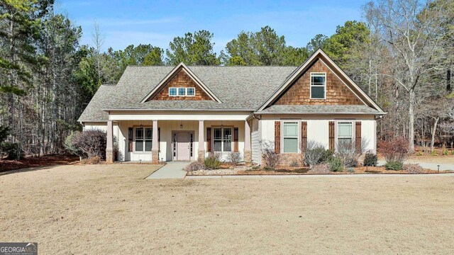 view of front of house featuring covered porch and a front lawn