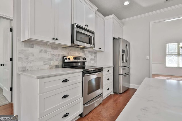 kitchen with white cabinets, a textured ceiling, decorative backsplash, light stone countertops, and appliances with stainless steel finishes