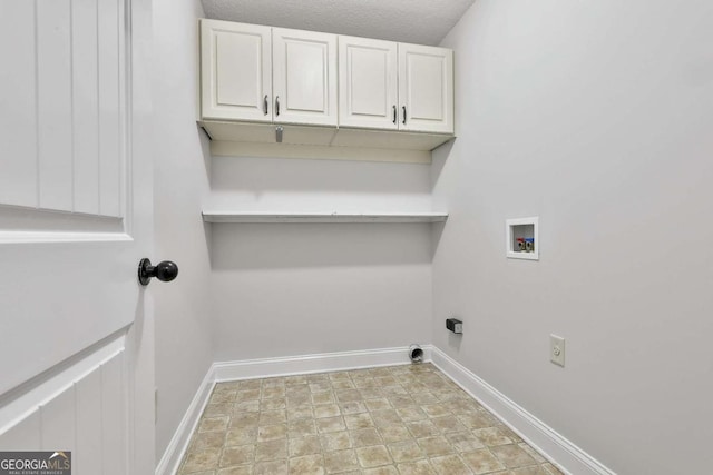 laundry area with a textured ceiling, cabinets, and washer hookup