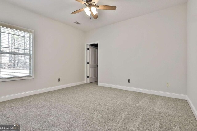 carpeted spare room with ceiling fan