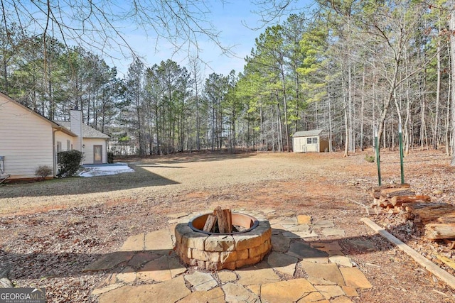 view of yard with an outdoor fire pit and a storage shed