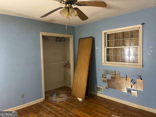 unfurnished bedroom with ceiling fan, a closet, and dark hardwood / wood-style floors