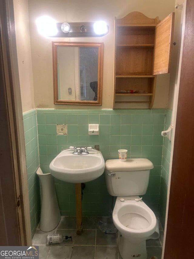 bathroom featuring tile walls, sink, tile patterned floors, and toilet