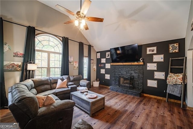 living room featuring vaulted ceiling, a fireplace, ceiling fan, and wood-type flooring