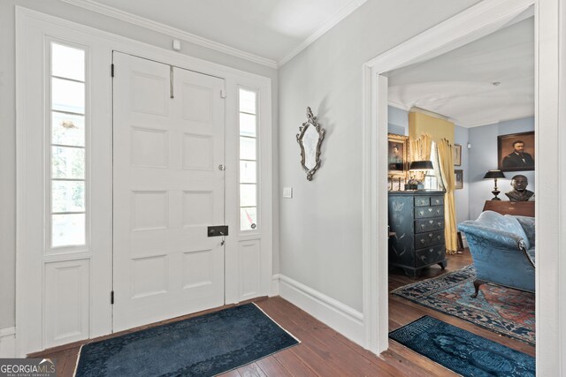 entryway with dark hardwood / wood-style flooring and crown molding