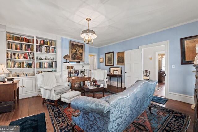 living room with built in features, ornamental molding, a chandelier, and dark hardwood / wood-style floors