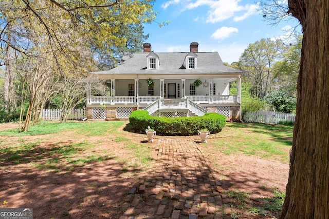 back of house featuring covered porch and a yard