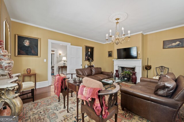 living room featuring light hardwood / wood-style floors, an inviting chandelier, and ornamental molding