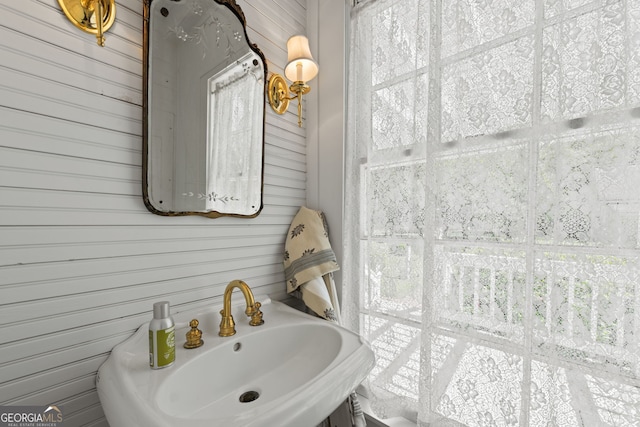 bathroom with sink and wooden walls